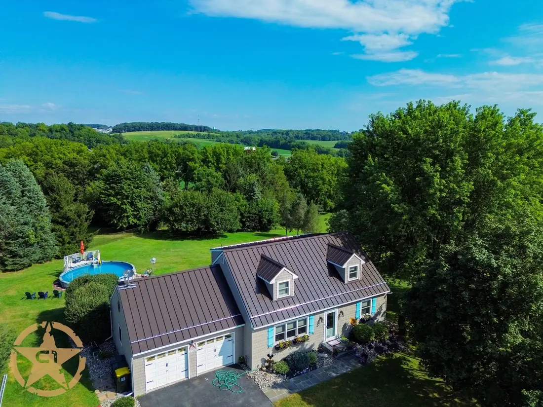 Aerial view of a completed standing seam metal roof on a residential home