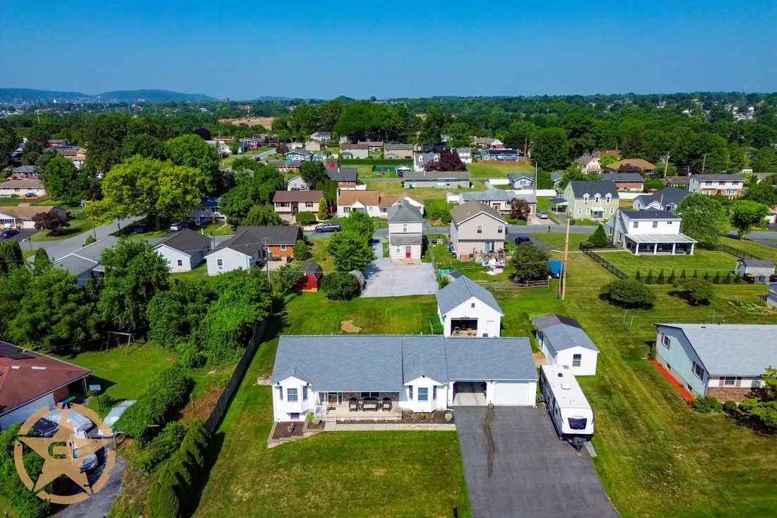Aerial view of a completed asphalt shingle roof replacement in a residential neighborhood