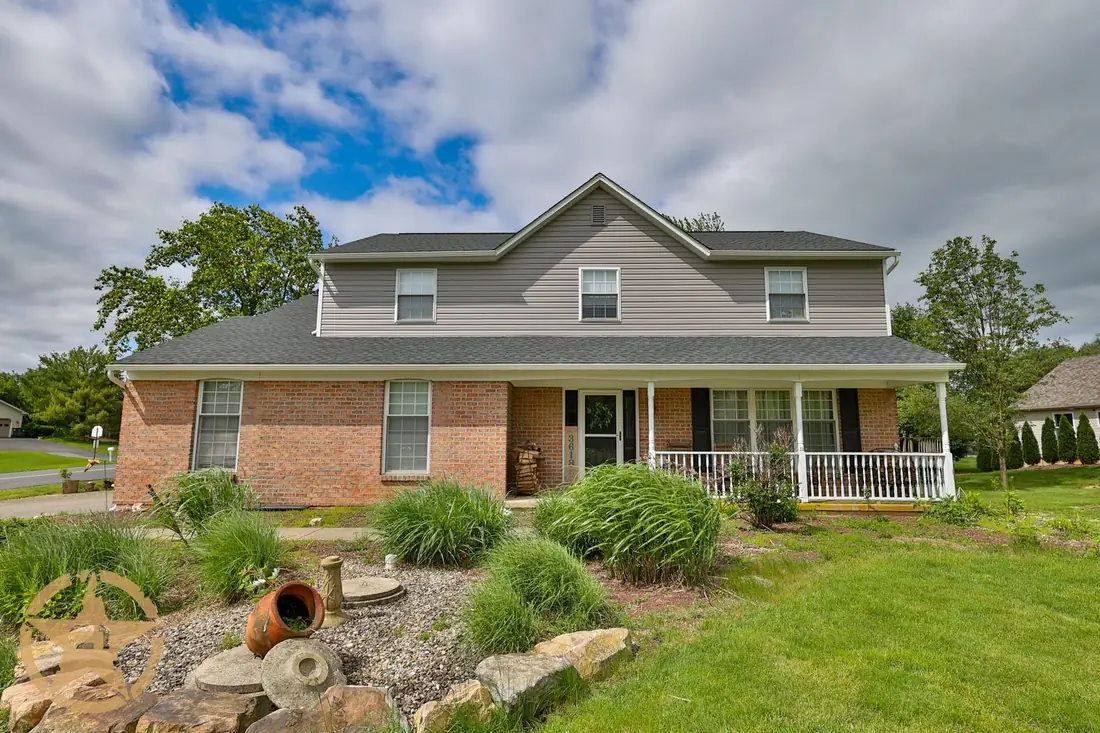 Completed exterior work on a brick and siding home with a covered porch