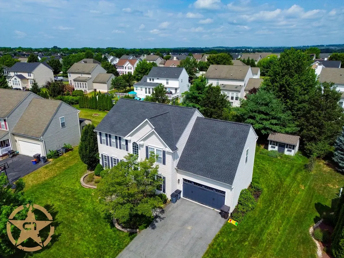 Aerial view of a completed asphalt shingle roof on a two story colonial