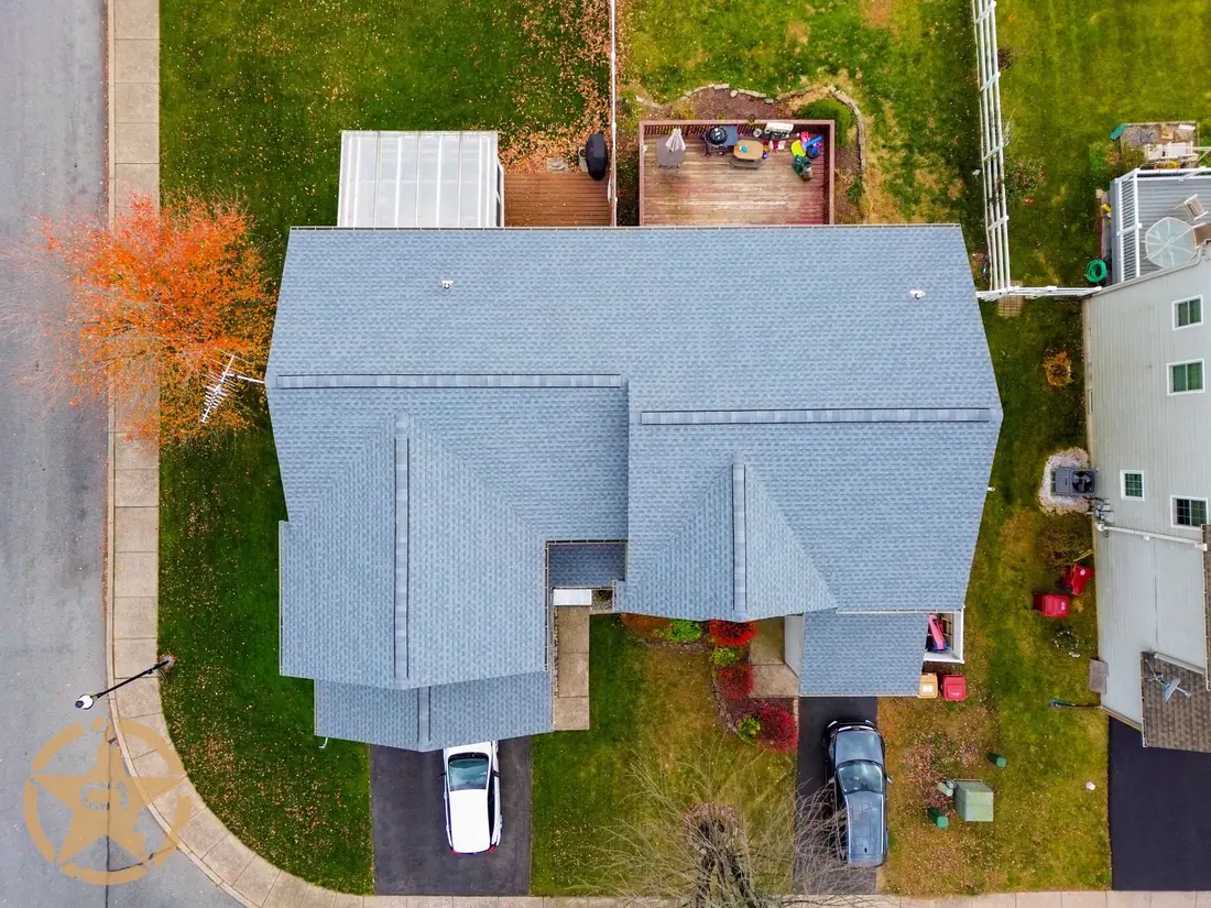 Overhead view of a completed asphalt shingle roof replacement across both sides of a twin home